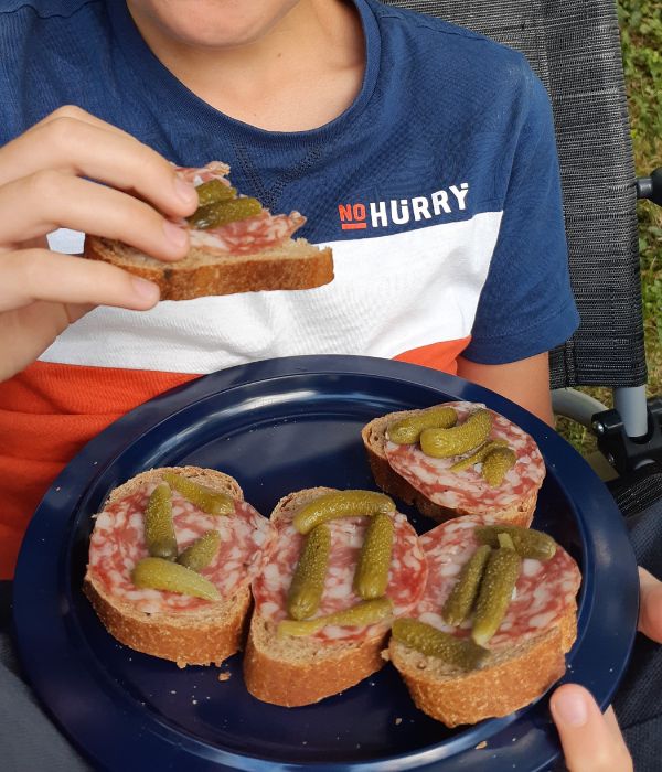 stokbrood met salami en augurk op een mepal bordje